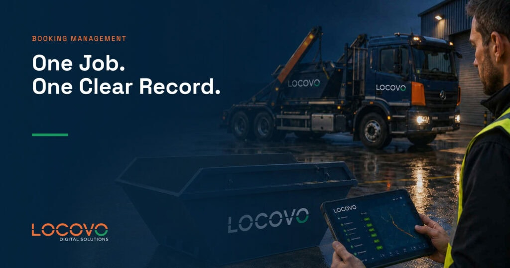 Operator using a tablet to manage skip hire jobs beside a branded lorry.